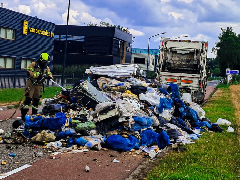 Inhoud vuilniswagen op straat gelost nadat deze vlam vat (VIDEO)